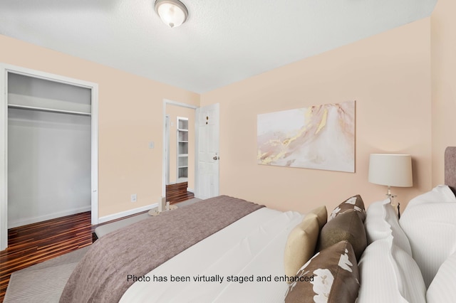 bedroom featuring a closet, wood finished floors, and baseboards