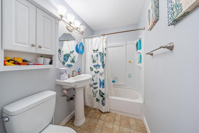 bathroom with stone finish floor, shower / bath combo with shower curtain, toilet, and baseboards