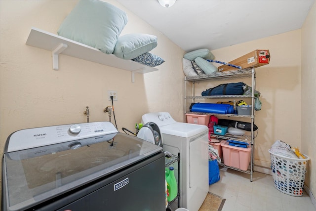 laundry room featuring laundry area, light floors, and washing machine and clothes dryer