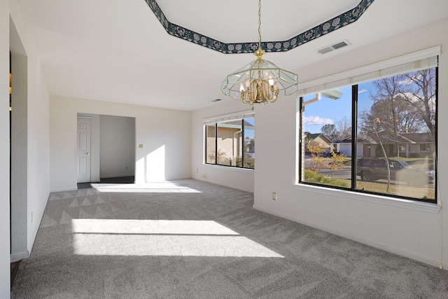 unfurnished room featuring carpet flooring, visible vents, baseboards, and an inviting chandelier