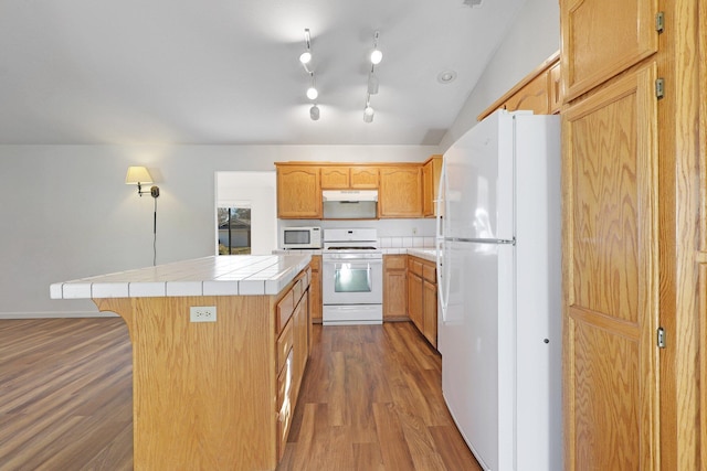 kitchen with white appliances, under cabinet range hood, dark wood-style flooring, and a center island