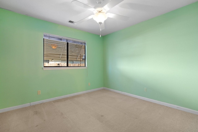 empty room featuring baseboards, visible vents, ceiling fan, and light colored carpet