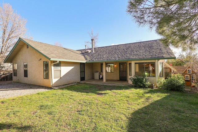 back of property featuring a yard, roof with shingles, a patio, and stucco siding