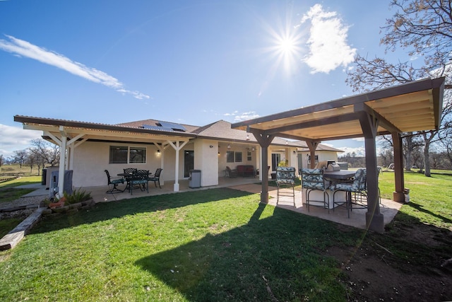 back of house featuring a yard, a patio, stucco siding, solar panels, and central AC