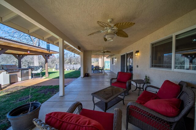 view of patio / terrace with outdoor dining area, an outdoor kitchen, a grill, a ceiling fan, and fence