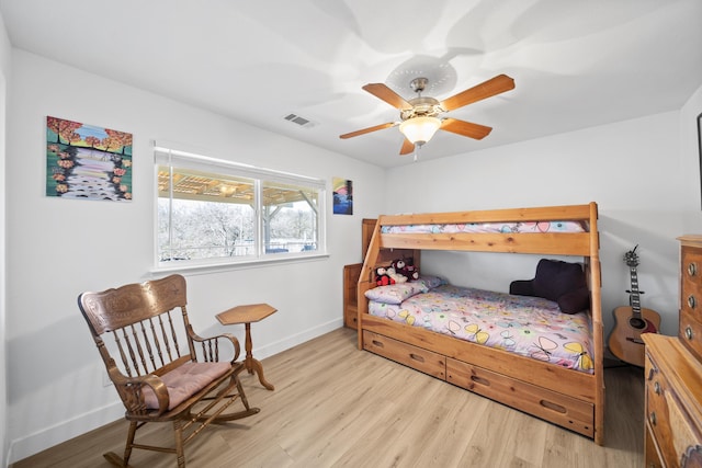 bedroom featuring light wood-style floors, baseboards, visible vents, and a ceiling fan