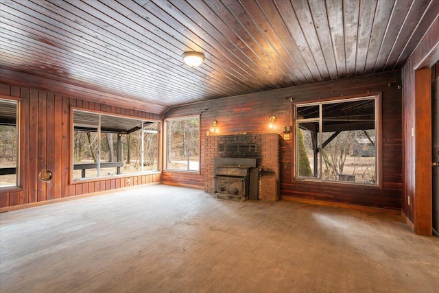 unfurnished living room featuring wooden ceiling, wooden walls, and a fireplace