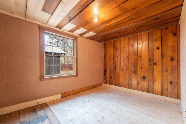 empty room featuring wooden walls, wood ceiling, and wood-type flooring