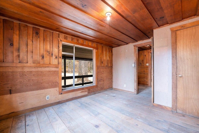 unfurnished room with wood-type flooring, wood ceiling, and wood walls