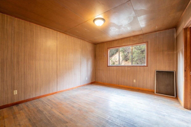 spare room with hardwood / wood-style floors and baseboards