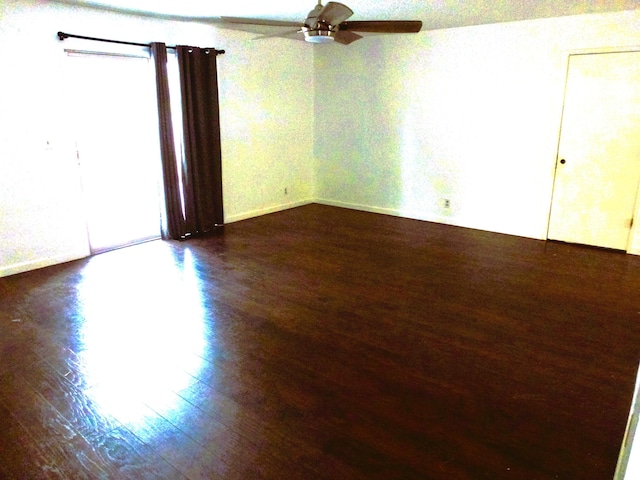 unfurnished room featuring dark wood-type flooring and ceiling fan