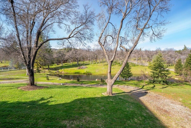 surrounding community featuring a water view and a lawn