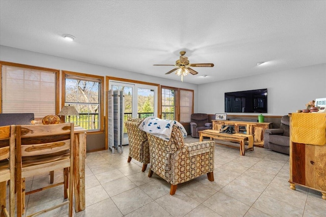 living room with ceiling fan and a textured ceiling