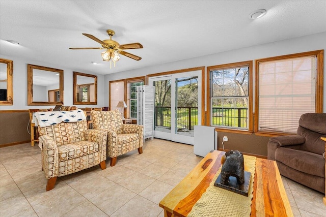 living room with light tile patterned floors, a textured ceiling, and ceiling fan