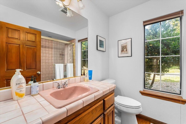 bathroom with vanity, an enclosed shower, and toilet