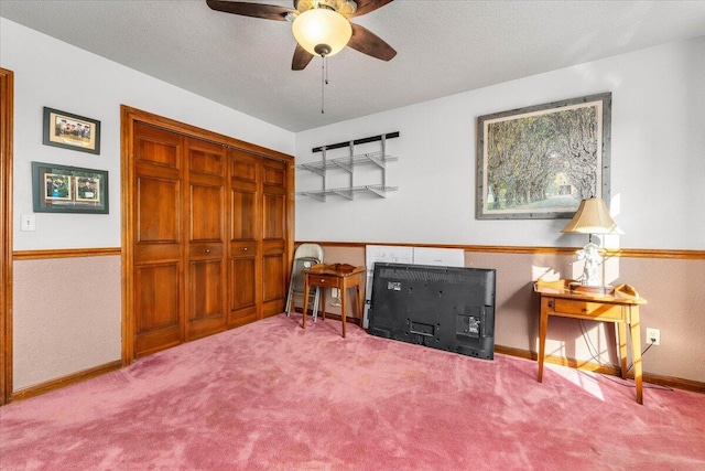 sitting room with ceiling fan, a textured ceiling, and carpet flooring