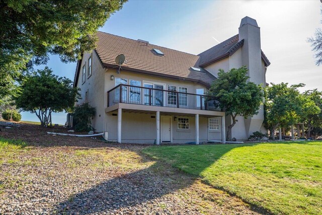 rear view of property featuring a wooden deck and a yard