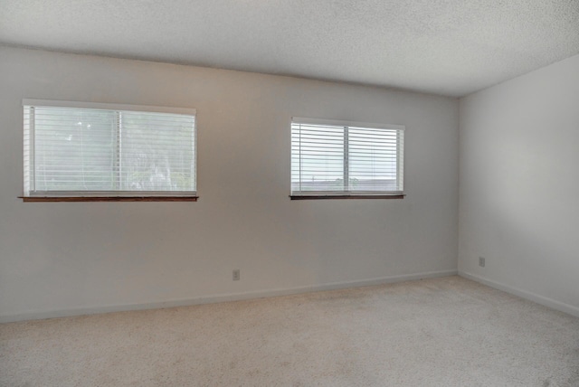 carpeted spare room with a textured ceiling