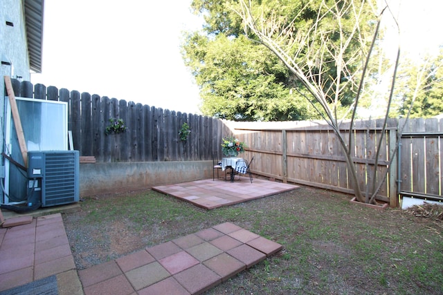 view of yard with central air condition unit and a patio area