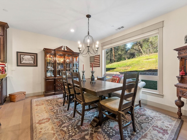 dining area with an inviting chandelier and light hardwood / wood-style floors