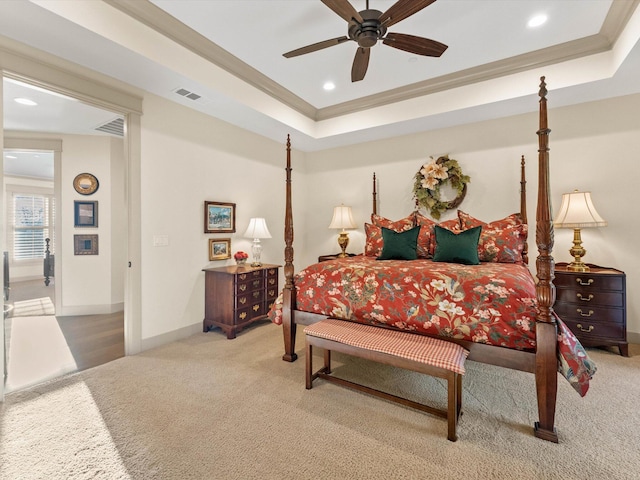 bedroom featuring a raised ceiling, ornamental molding, carpet floors, and ceiling fan