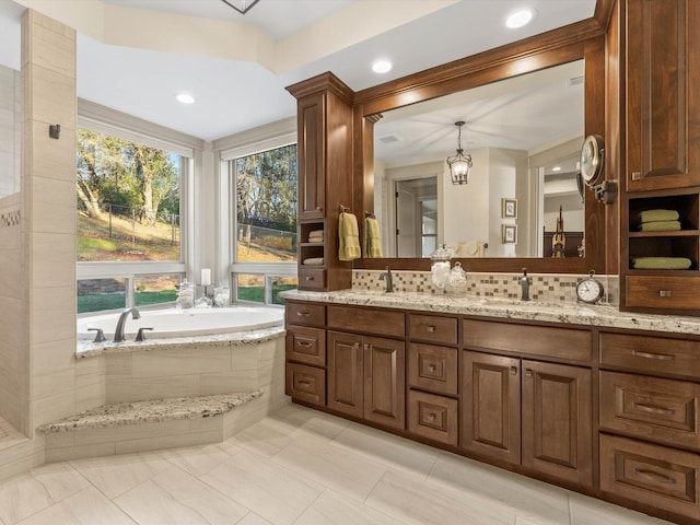 bathroom featuring vanity and tiled bath