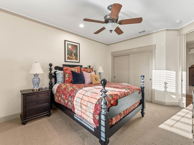 bedroom with light carpet, crown molding, a closet, and ceiling fan