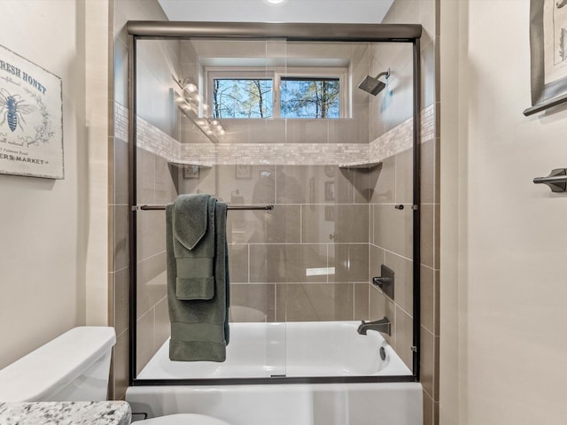 bathroom with shower / bath combination with glass door and toilet