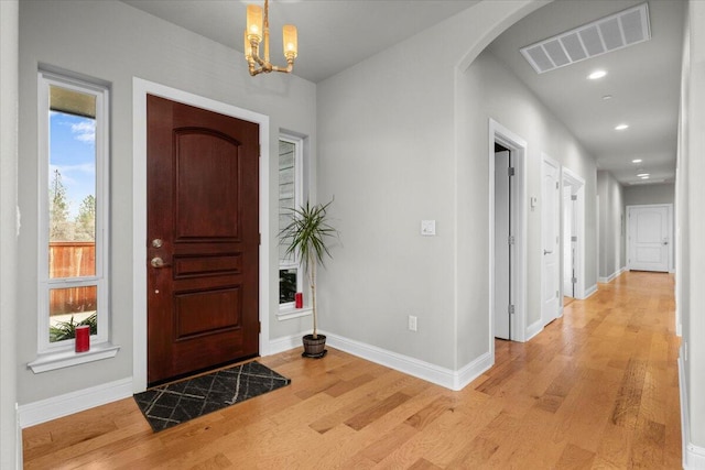 foyer with a notable chandelier and light hardwood / wood-style flooring