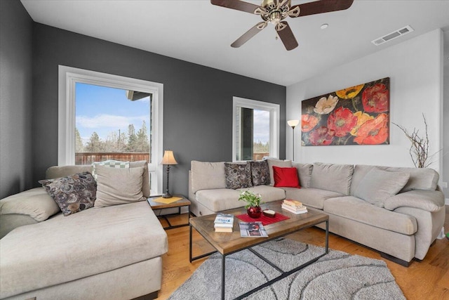 living room with light hardwood / wood-style flooring and ceiling fan