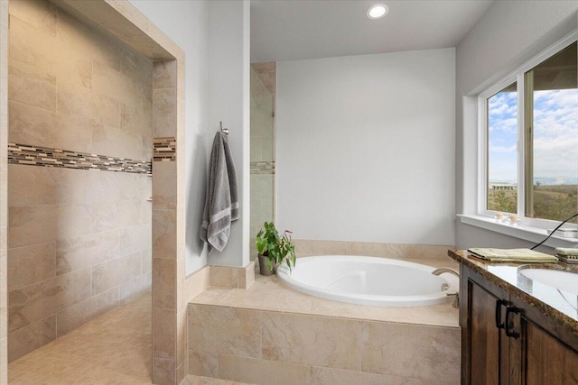 bathroom with vanity and shower with separate bathtub