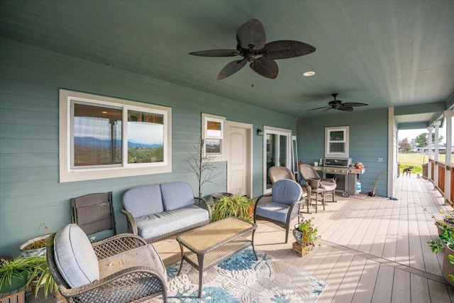 wooden deck with an outdoor hangout area and ceiling fan