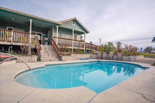 view of pool with a wooden deck and ceiling fan