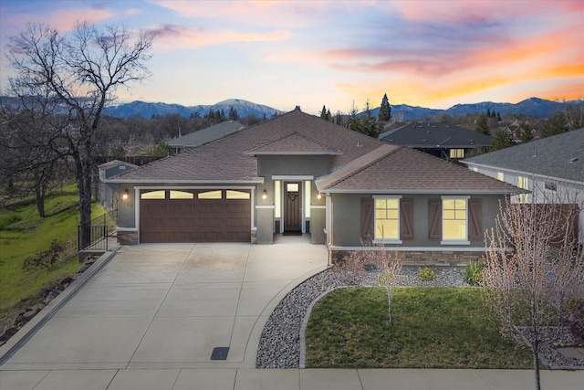 view of front of home with a garage and a mountain view