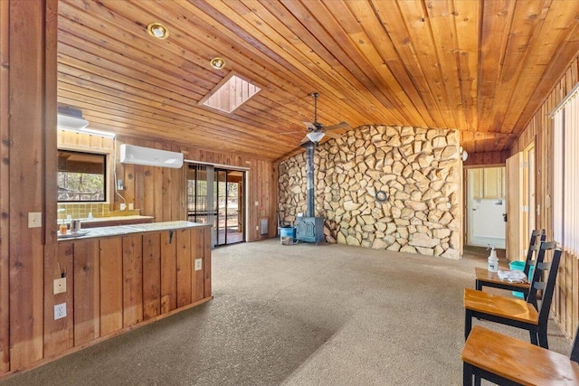 living room featuring french doors, wooden ceiling, lofted ceiling with skylight, and a wood stove