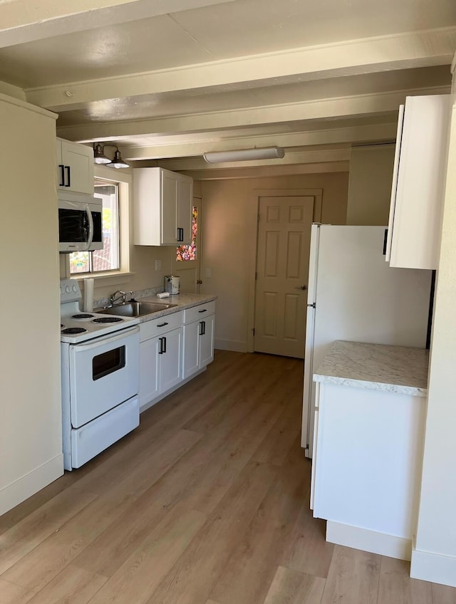 kitchen featuring white appliances, a sink, baseboards, white cabinets, and light wood-type flooring