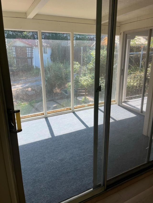 entryway featuring beam ceiling and a wealth of natural light