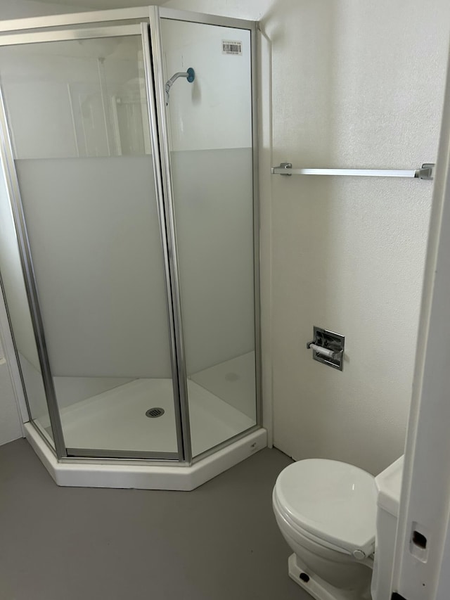 full bath featuring a shower stall and toilet