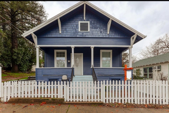 bungalow-style home with a porch and a fenced front yard