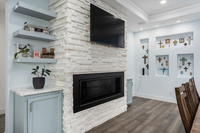 living room featuring dark hardwood / wood-style flooring, crown molding, and a fireplace