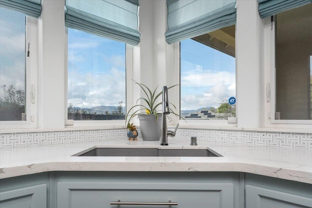 kitchen featuring tasteful backsplash, gray cabinets, sink, and a wealth of natural light