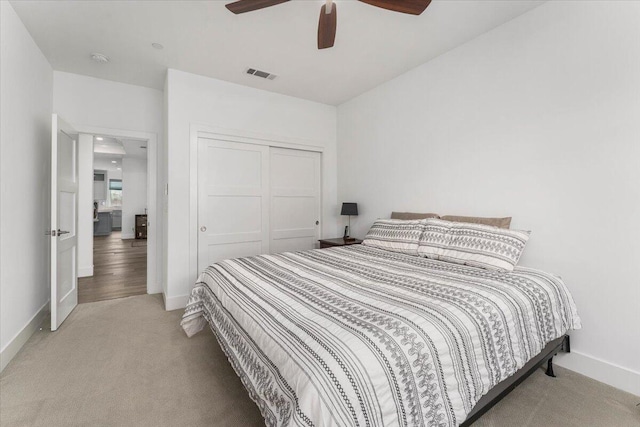 bedroom with light carpet, a closet, and ceiling fan