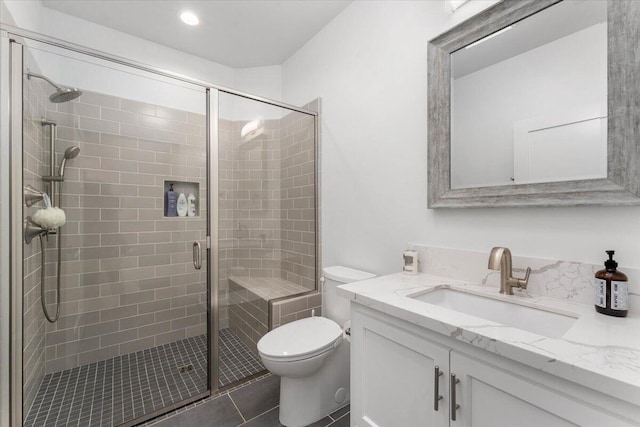 bathroom featuring vanity, a shower with shower door, tile patterned floors, and toilet