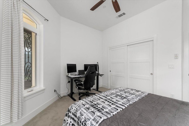 bedroom with light carpet, ceiling fan, and a closet