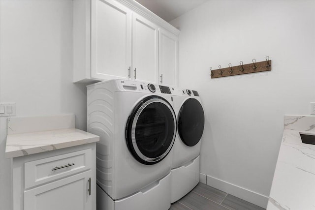 laundry room with cabinets and washing machine and clothes dryer