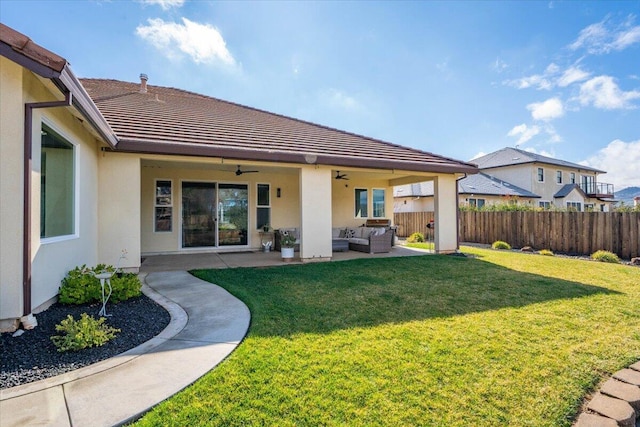 rear view of house featuring a yard, an outdoor hangout area, a patio, and ceiling fan