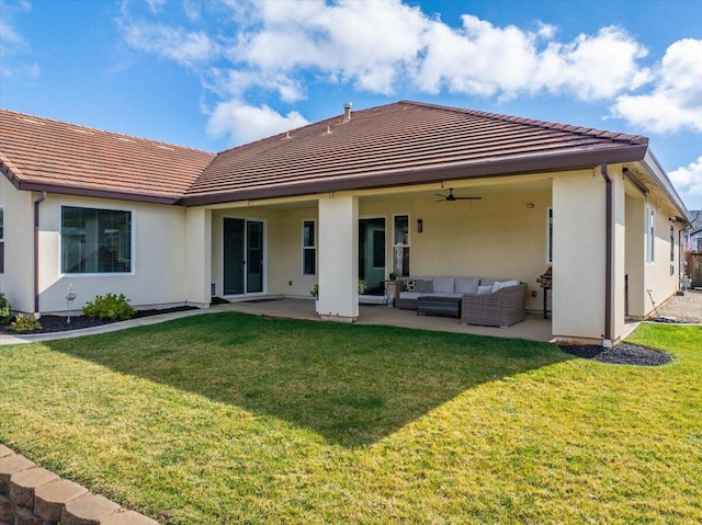 back of house featuring an outdoor living space, a yard, a patio area, and ceiling fan