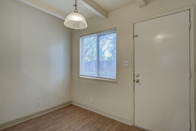 interior space with beamed ceiling and hardwood / wood-style floors