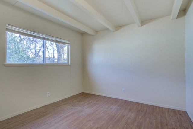 unfurnished room with beamed ceiling and light hardwood / wood-style floors