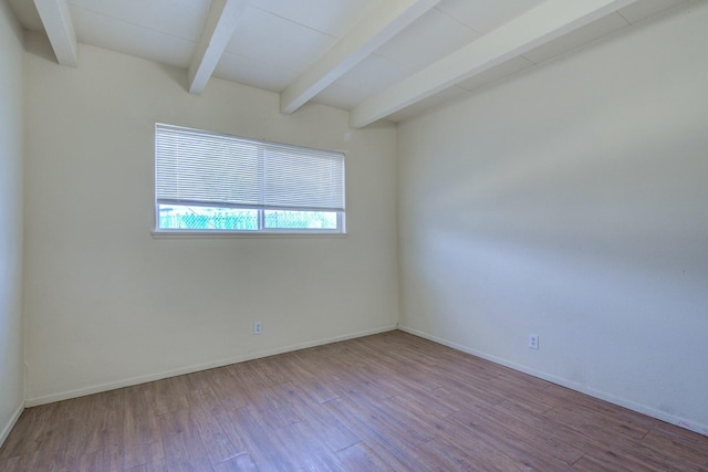 empty room with beam ceiling and light hardwood / wood-style floors